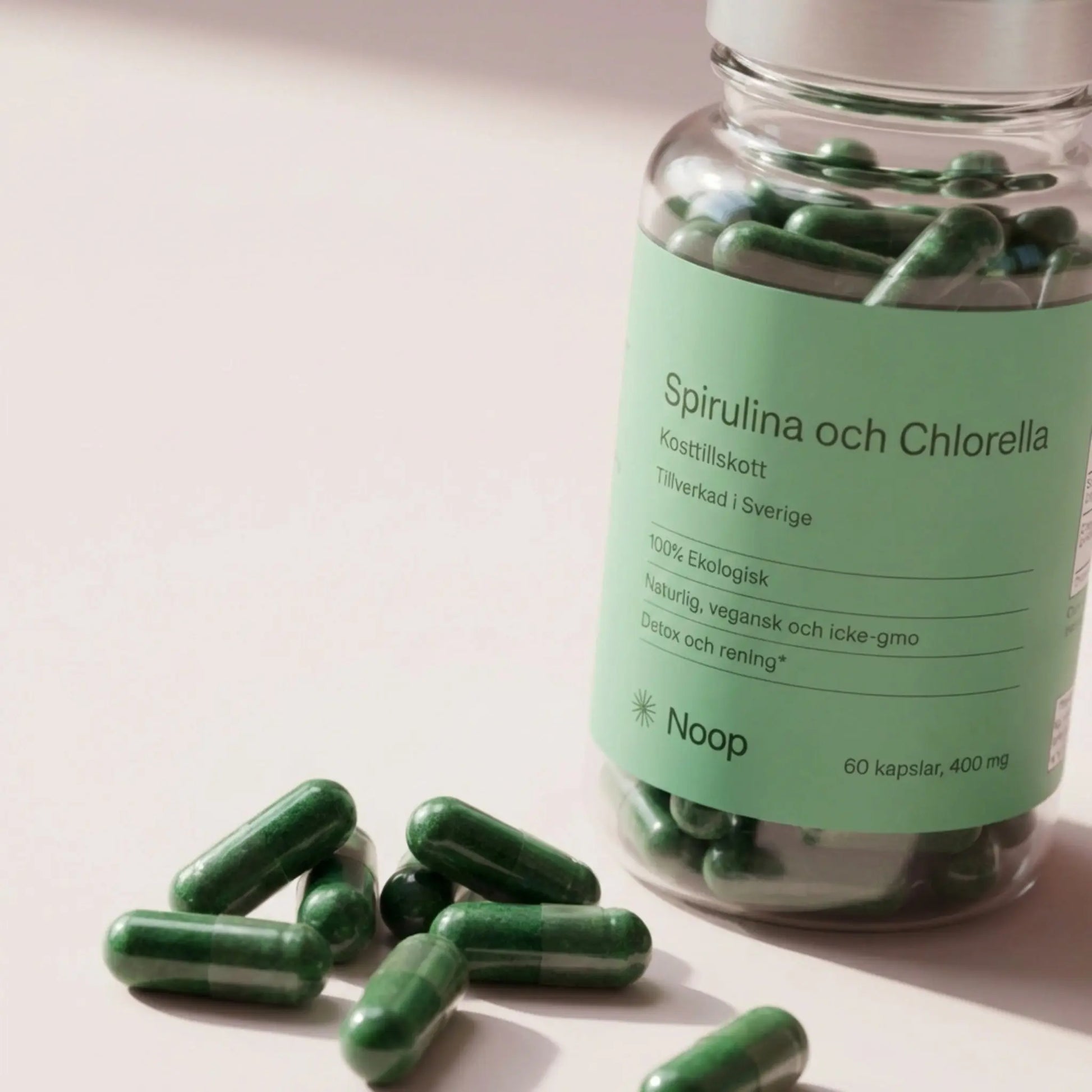 Spirulina & Chlorella Noop – närbild på flaska med utspillda kapslar